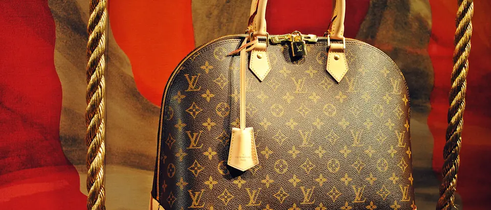 A Louis Vuitton Monogram Alma bag displayed on a swing in a shop window