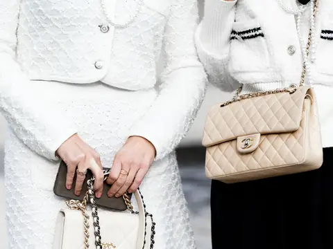Two women in white tweed carrying beige and white Chanel Classic Flap bags