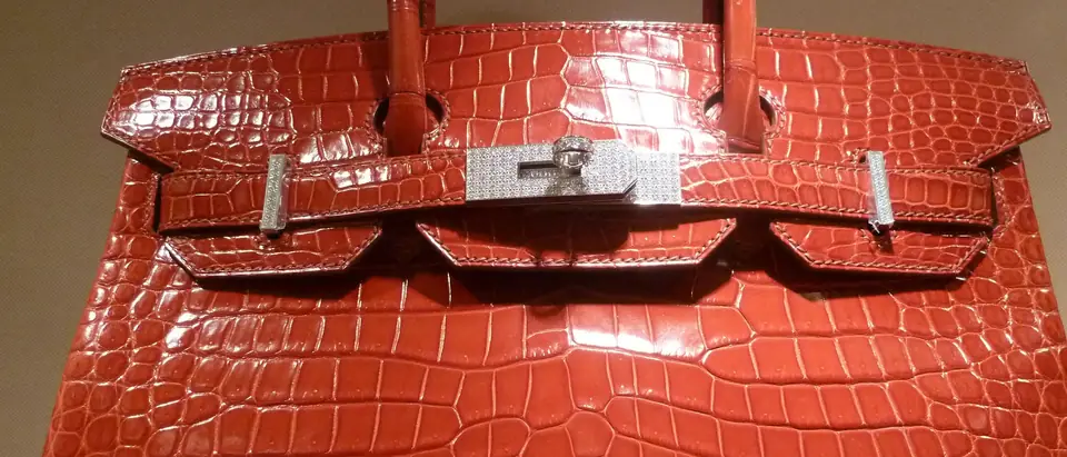 Close view of a glossy red crocodile Hermes Birkin with palladium hardware