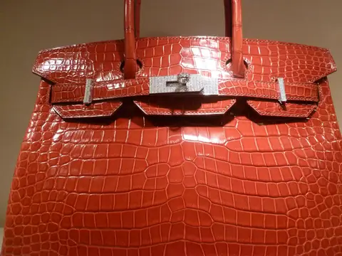 Close view of a glossy red crocodile Hermes Birkin with palladium hardware